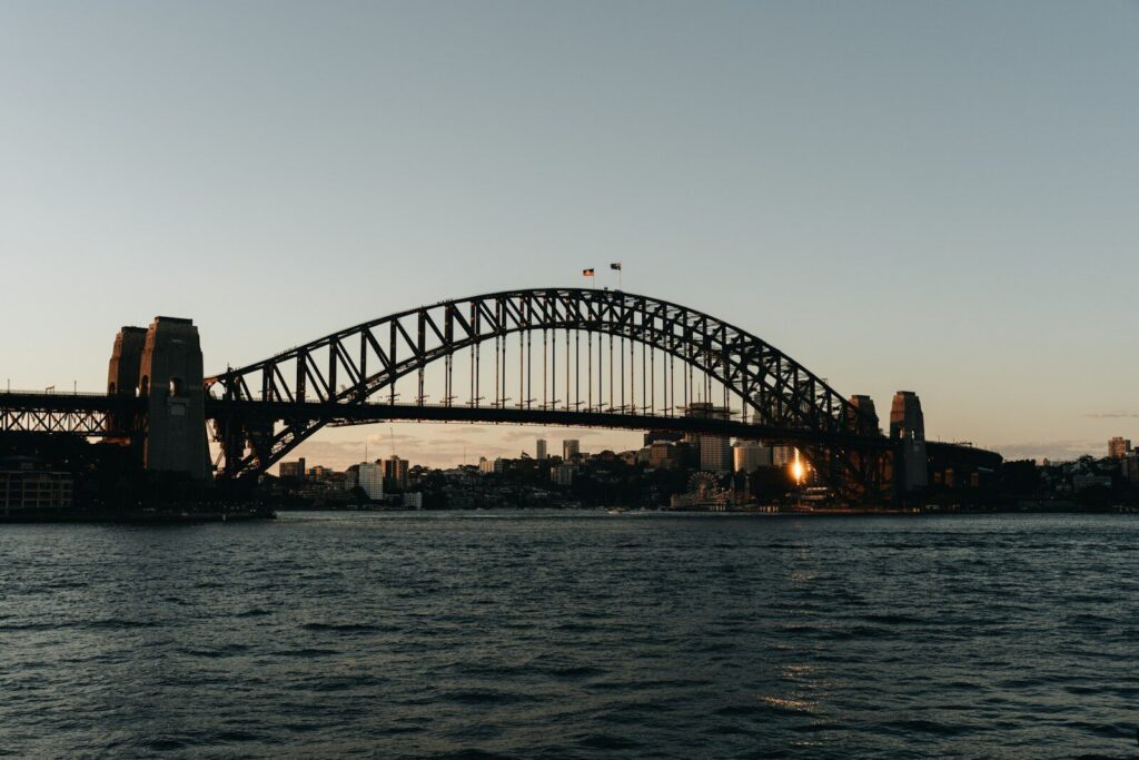 Sydney harbour bridge at sunset with calm water